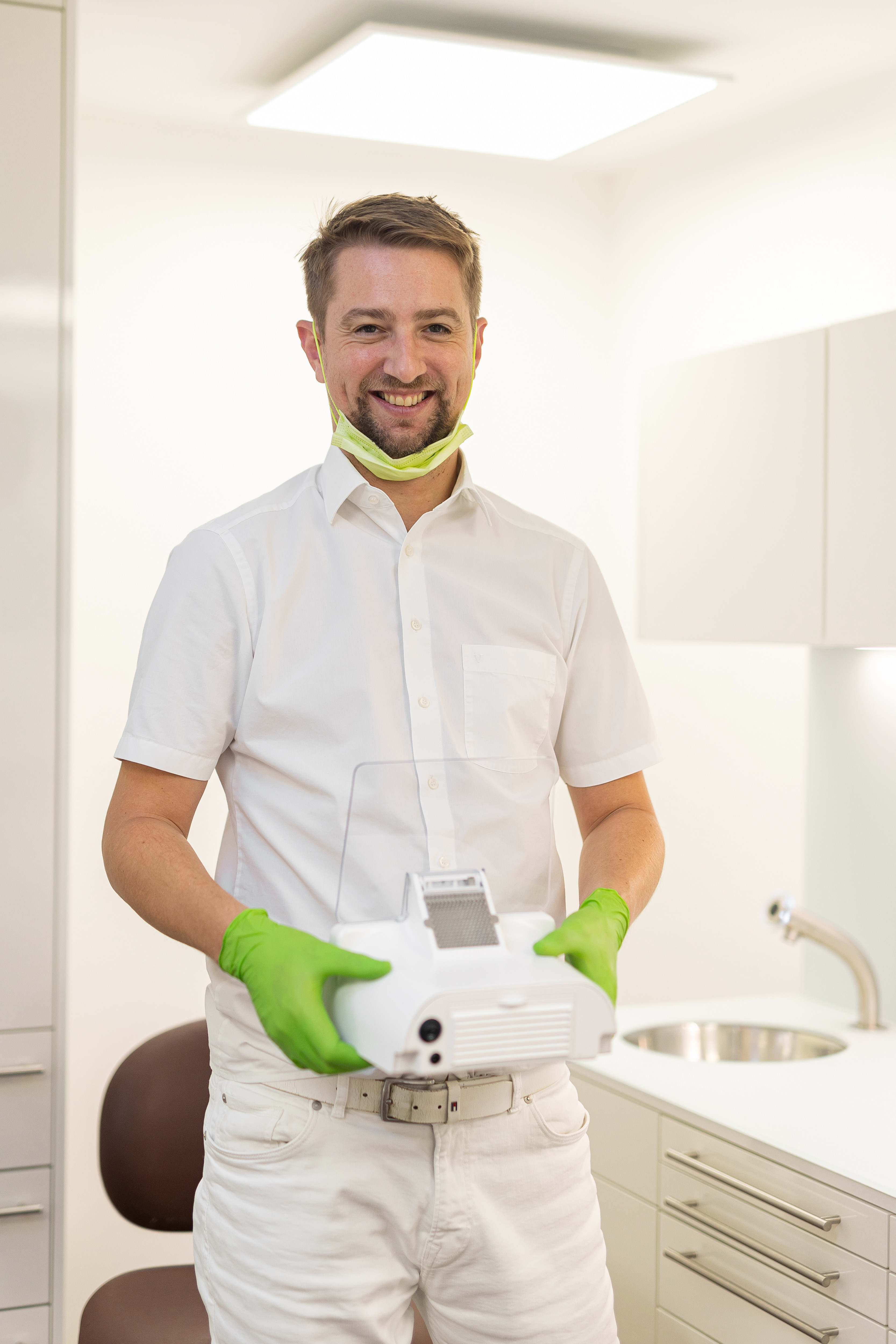 Dentist ținând aspiratorul SILENT XS Renfert în cabinet